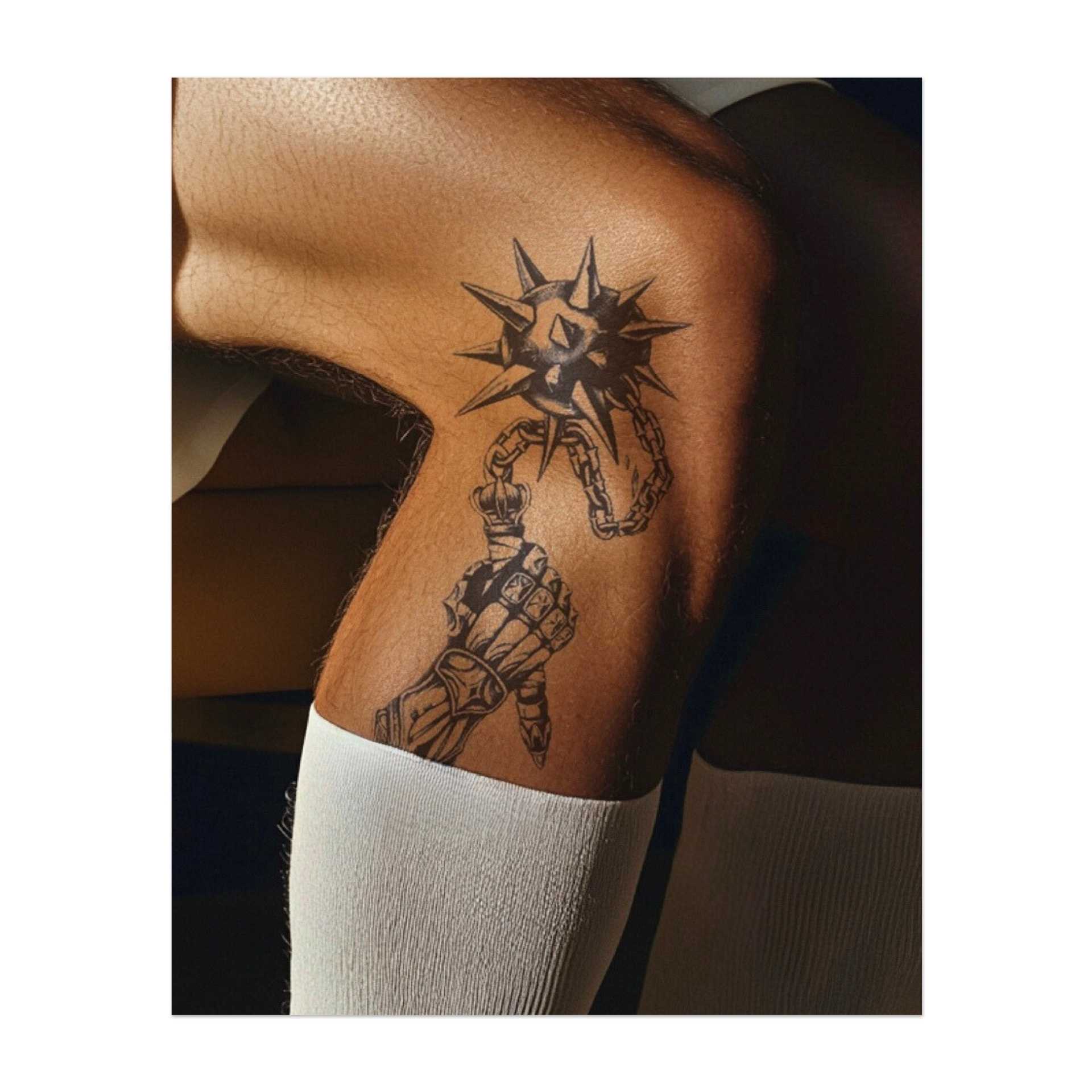 Eine gepanzerte Hand, die einen spitzen Morgenstern an einer Kette hält. Dieses Design repräsentiert Stärke, Widerstandsfähigkeit und die Fähigkeit, Herausforderungen mit Kraft und Entschlossenheit zu überwinden. Ideal für jemanden, der seinen Kriegergeist umarmt.