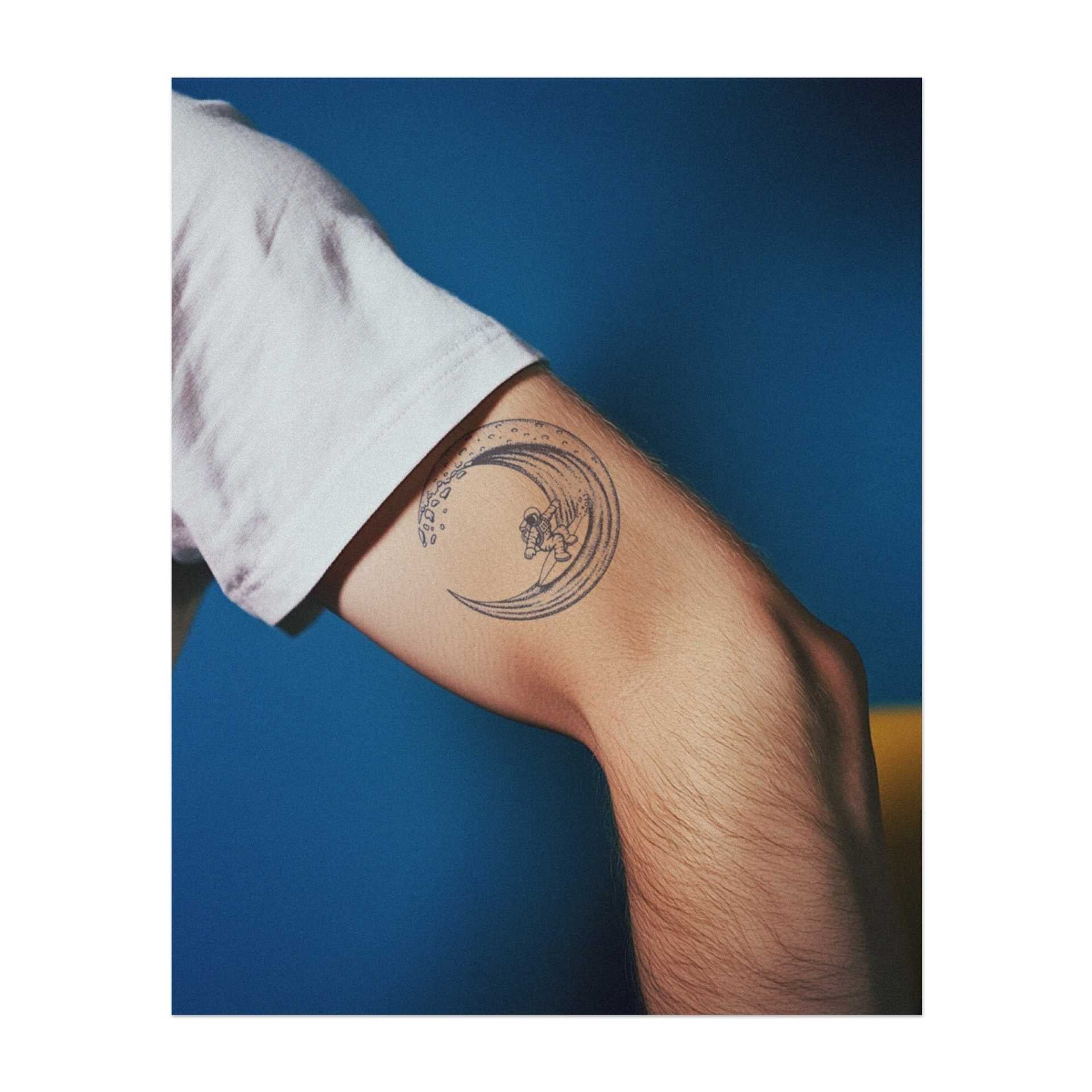 Ein Surfer (Astronaut), der eine riesige Welle reitet und die Energie des Ozeans mit dem Nervenkitzel des Ritts verbindet. Dieses Tattoo symbolisiert Abenteuer, Freiheit und das Umarmen des Lebensflusses, perfekt für diejenigen, die das Leben auf der Suche nach Aufregung und der Schönheit der Natur leben.