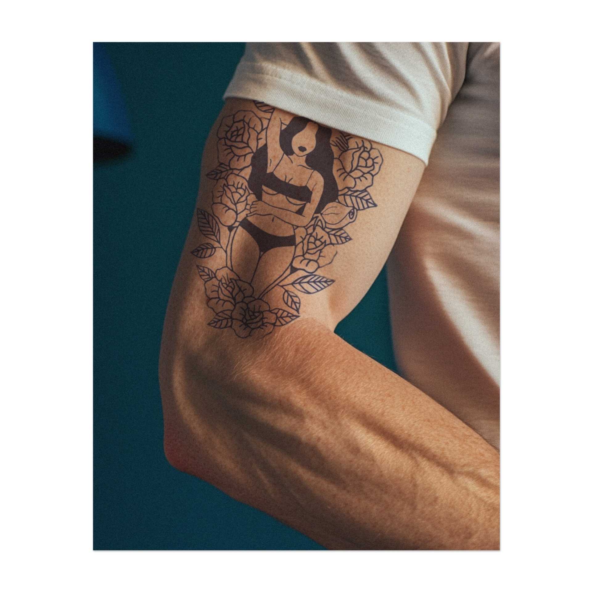 Eine anmutige Frau, umgeben von Rosen, die Schönheit und Selbstvertrauen verkörpert. Mit ihrer entspannten Haltung symbolisiert dieses Tattoo Femininekeit und Eleganz. Ein perfektes Design für jemanden, der seine innere Stärke schätzt und den zarten Charme der Natur liebt.