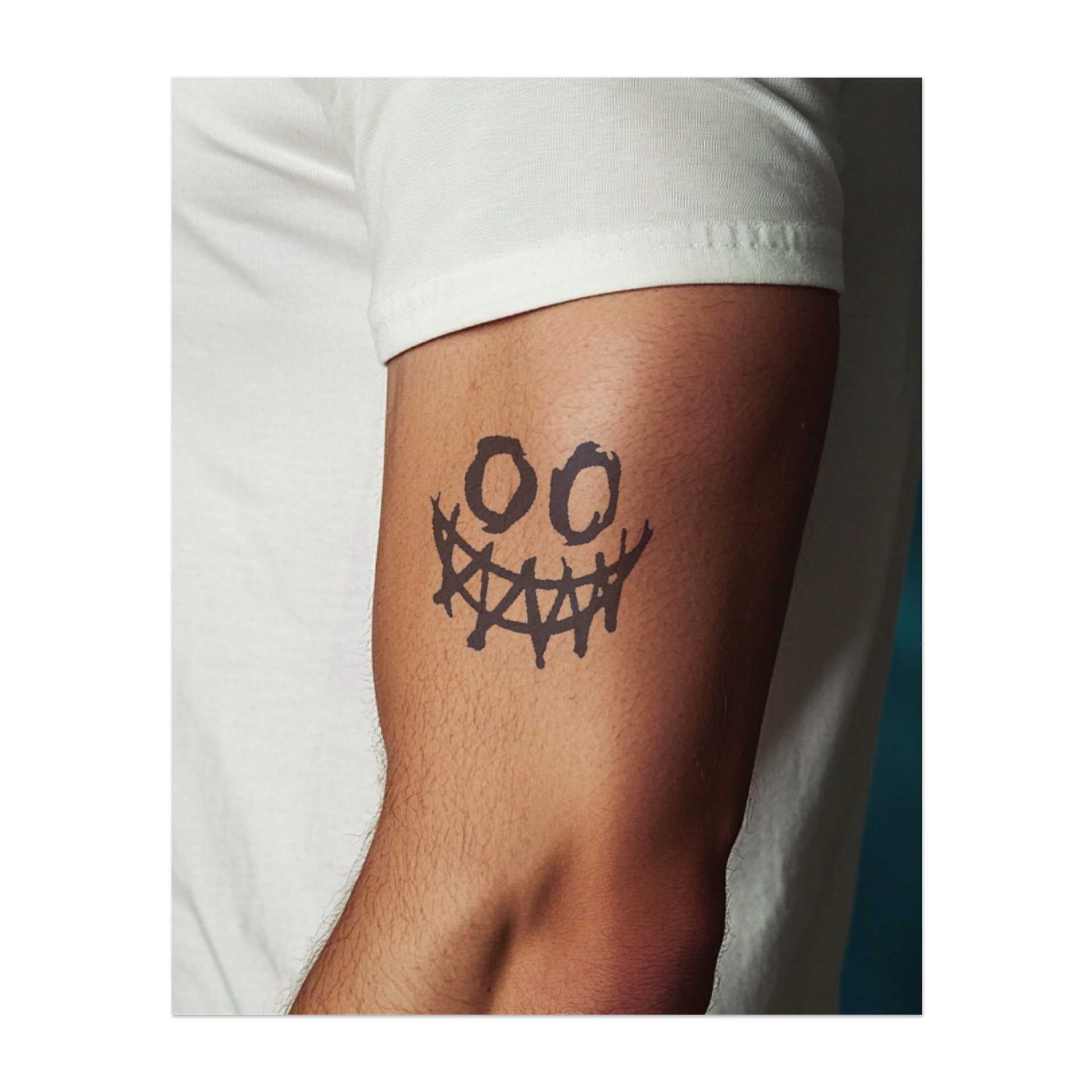 Ein verzerrtes, gruseliges Grinsen mit scharfen Zähnen und tropfenden Details. Dieses Tattoo symbolisiert Unfug, Kühnheit und das Umarmen des Unkonventionellen, ideal für diejenigen, die Normen herausfordern und auffallen möchten.